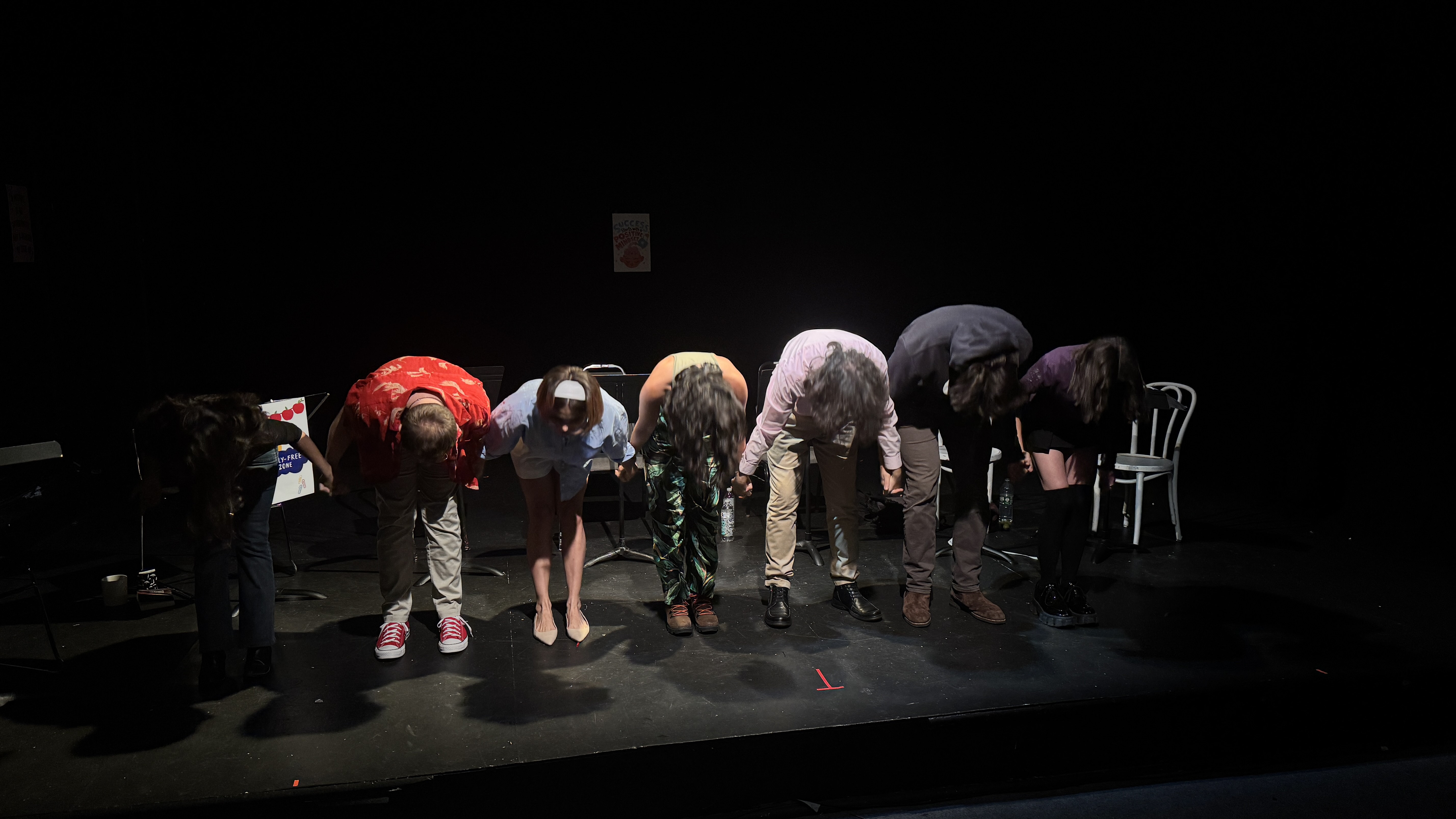 Performer centered between props in a moody frame