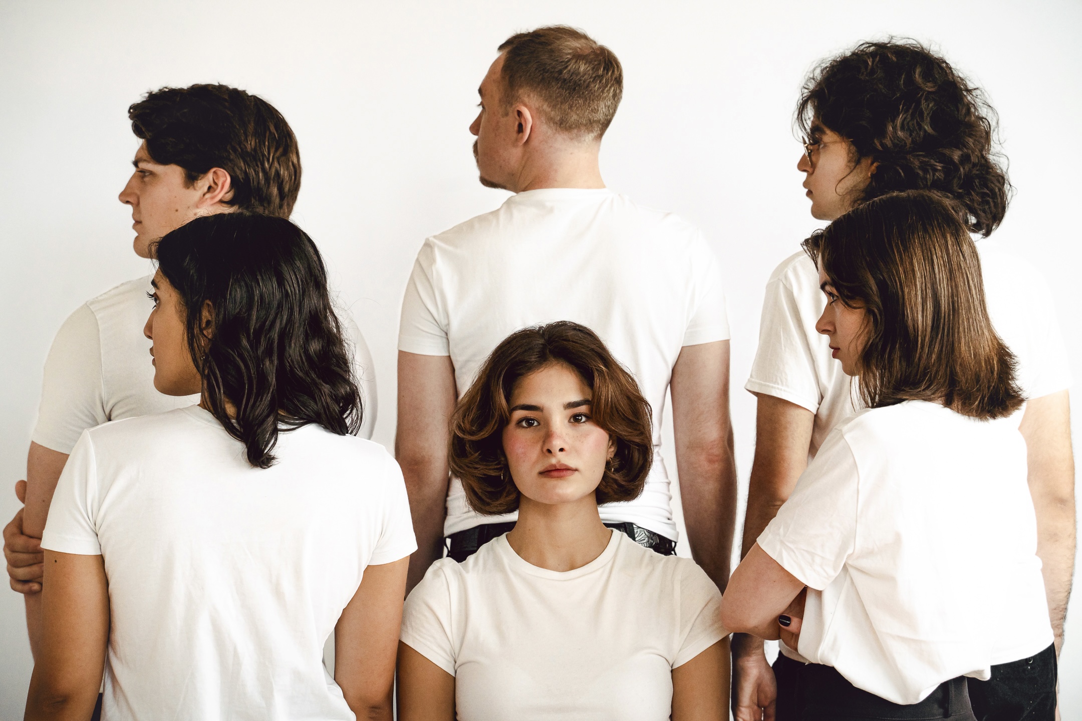Cast huddled backstage in the red glow of the wings